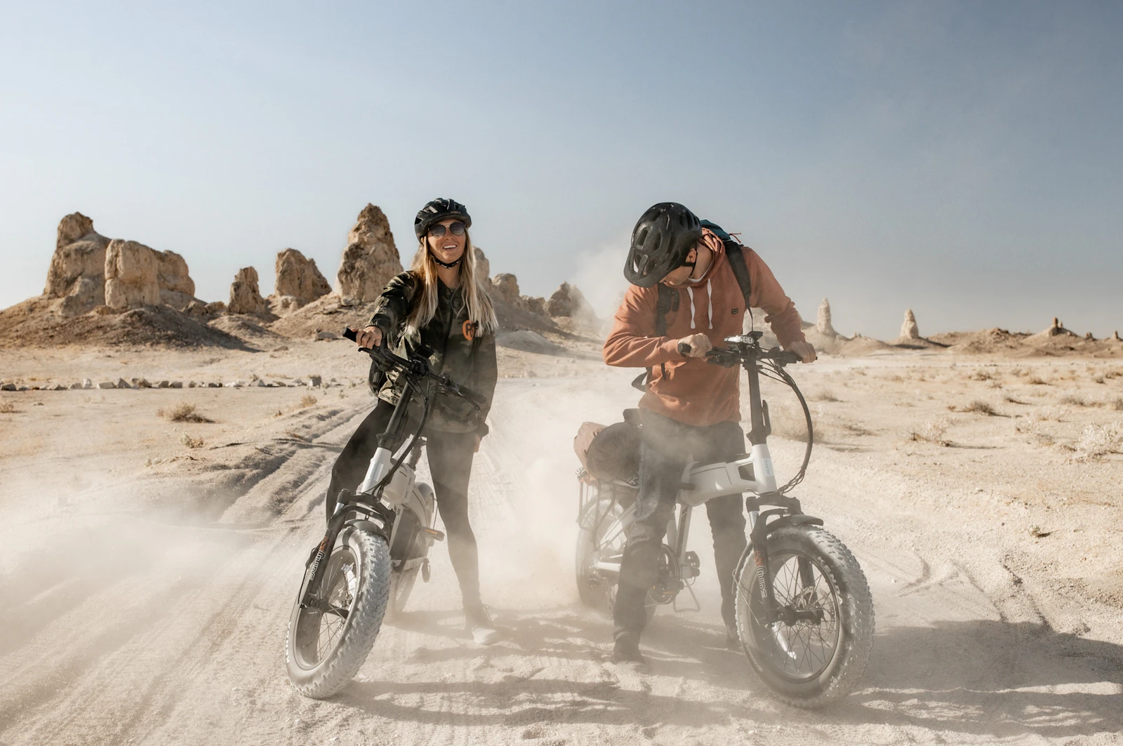 An image of two people riding Aventon bikes in a desert
