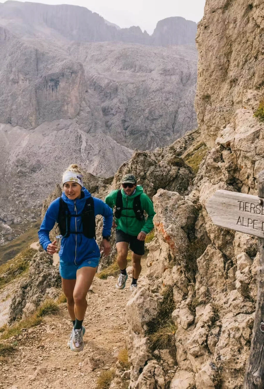 Female and male hiking uphill using Stio equipment