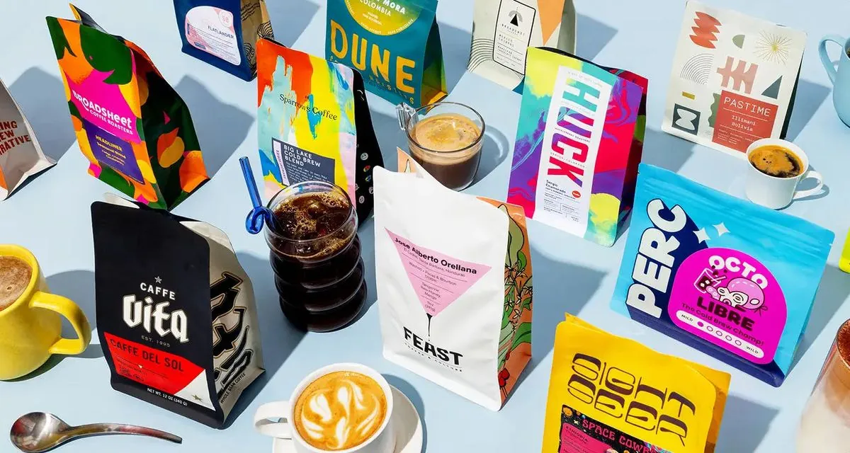 Bags of coffee from independent roasters laid out with brewed cups